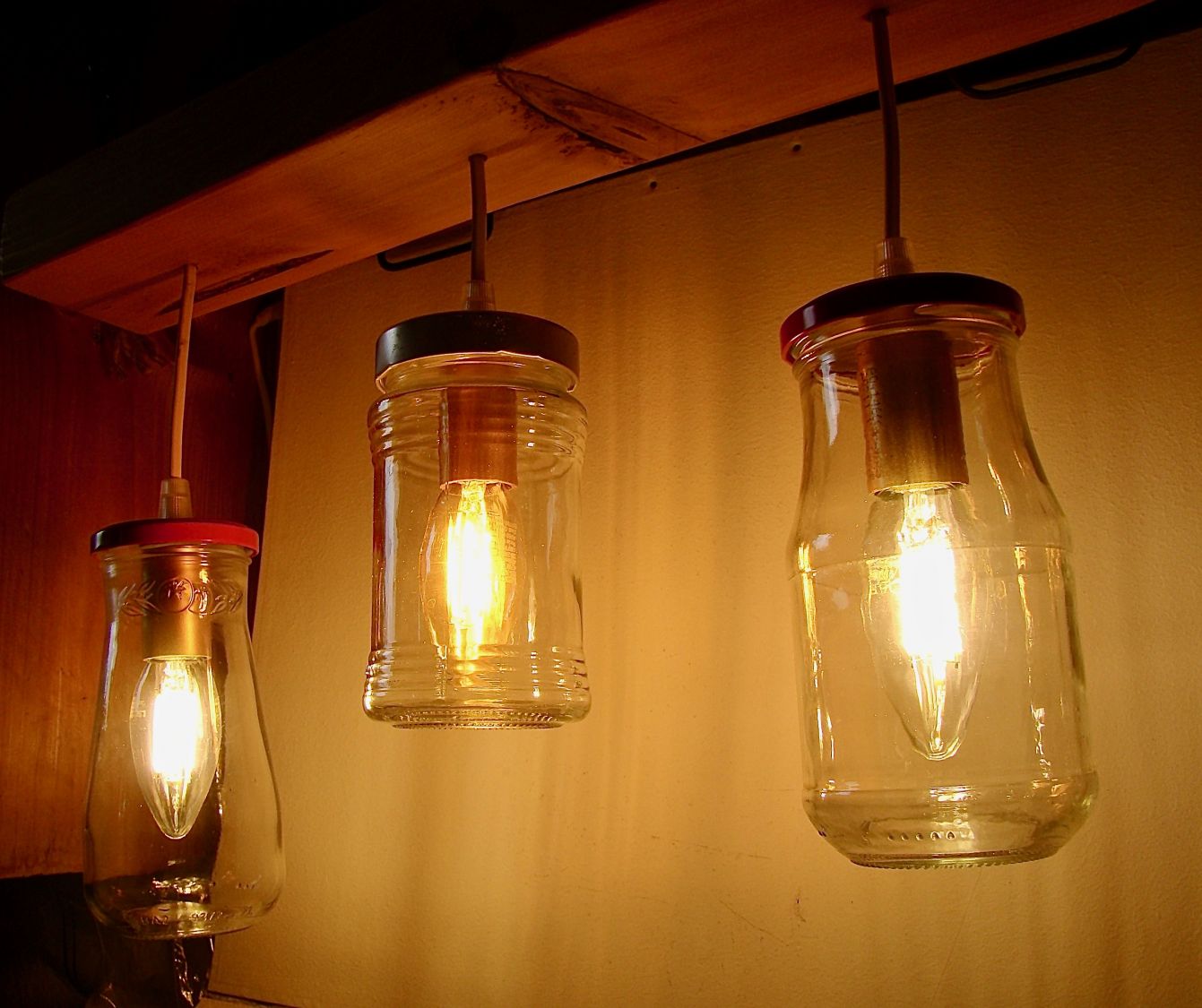 Pequeno candelabro com jarros reciclados e madeira.