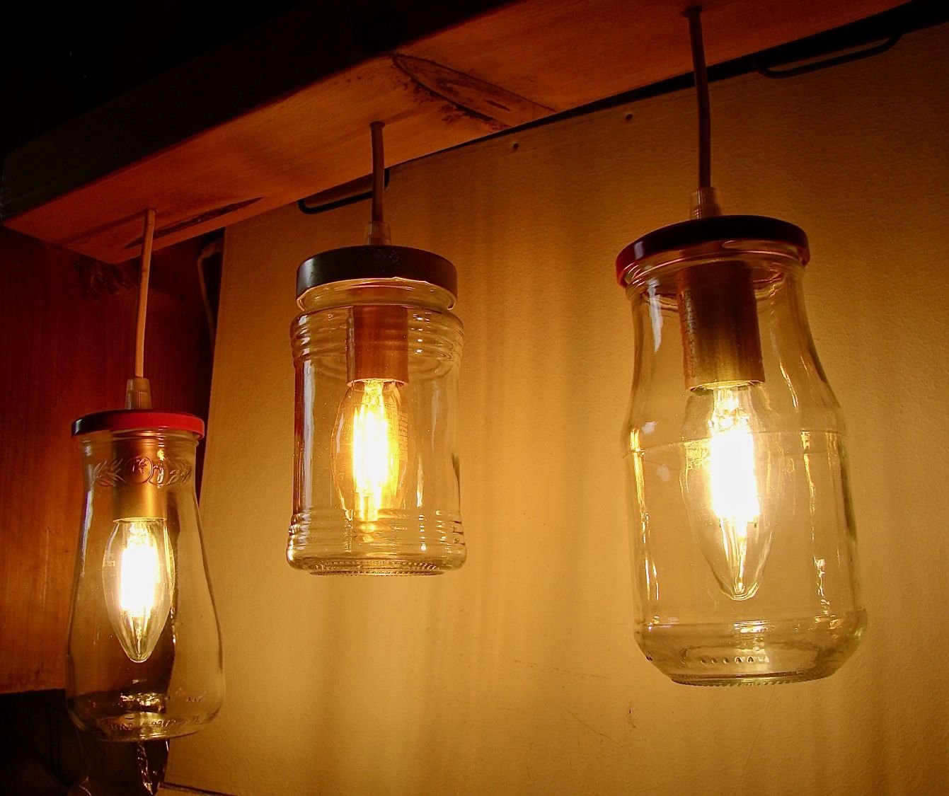 Pequeno candelabro com jarros reciclados e madeira.