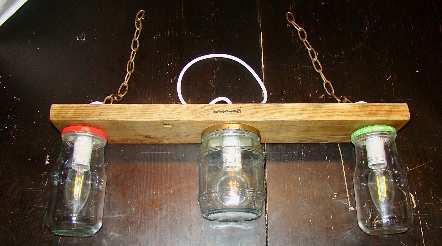 Pequeno candelabro com jarros reciclados e madeira.