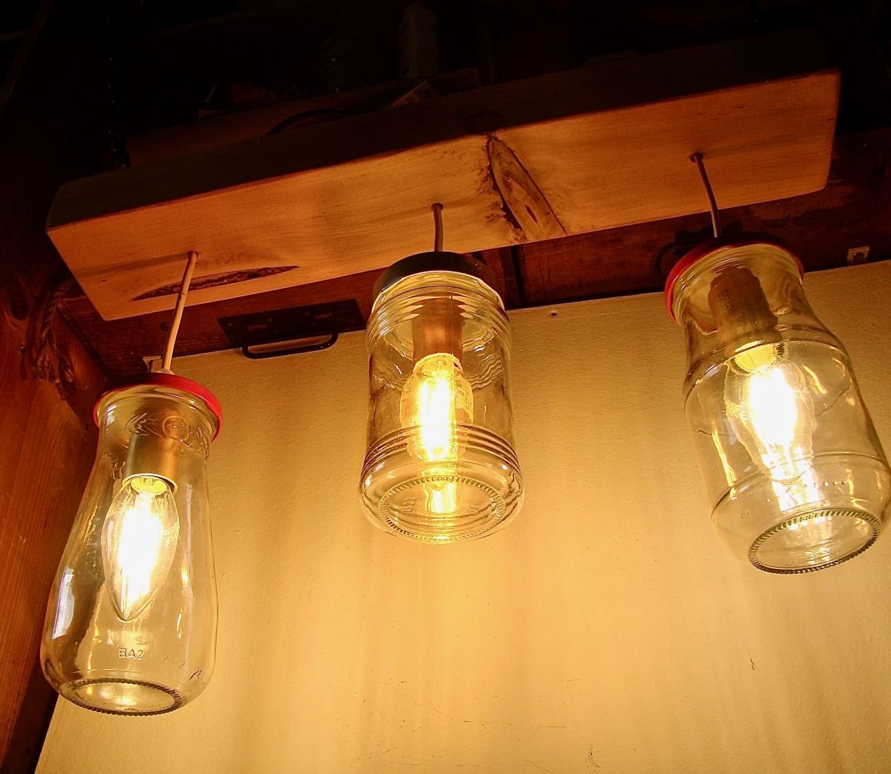 Pequeno candelabro com jarros reciclados e madeira.