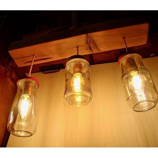 Pequeno candelabro com jarros reciclados e madeira.