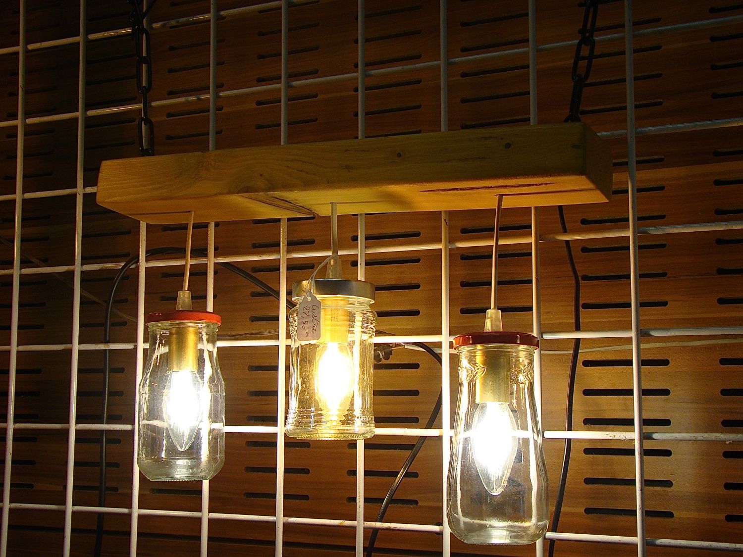 Pequeno candelabro com jarros reciclados e madeira.