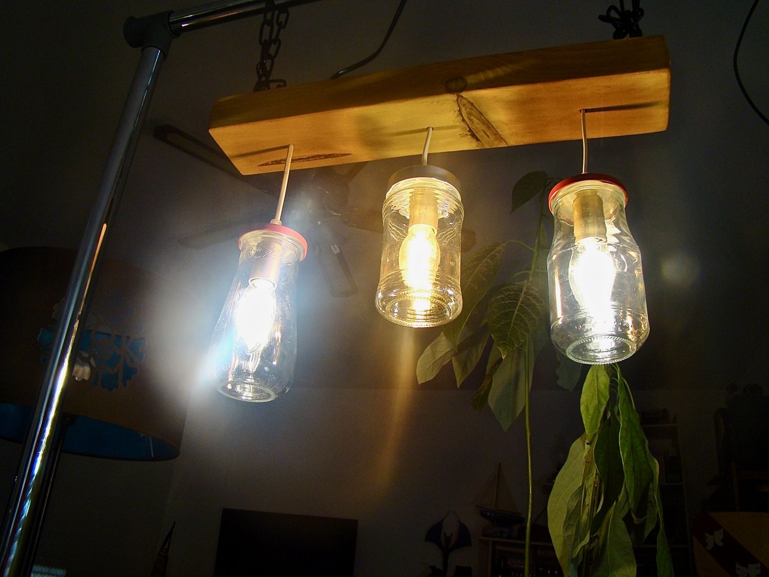 Pequeno candelabro com jarros reciclados e madeira.