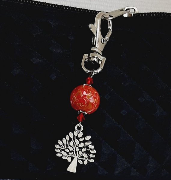 porta-chaves em prata com s&iacute;mbolo da &aacute;rvore da vida e p&eacute;rola feita &agrave; m&atilde;o em vermelho vivo e dourado