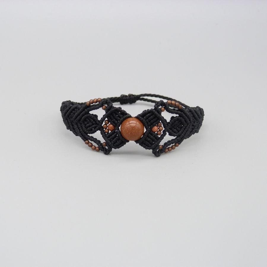 Pulseira micromacramé preta com uma conta central de "pedra sol"
