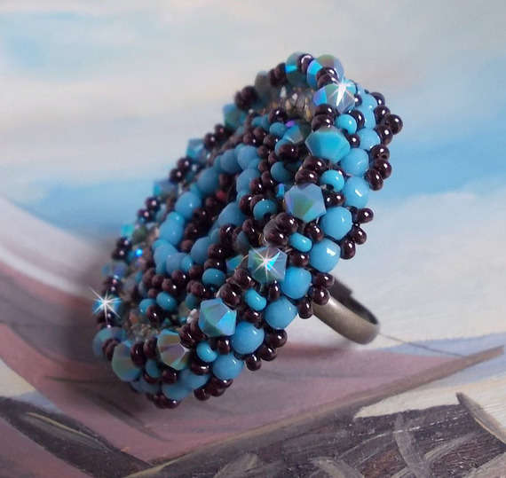 Anel naïade bordado com uma resina azul turquesa e cabochon de cristal, um belo jogo de luz.