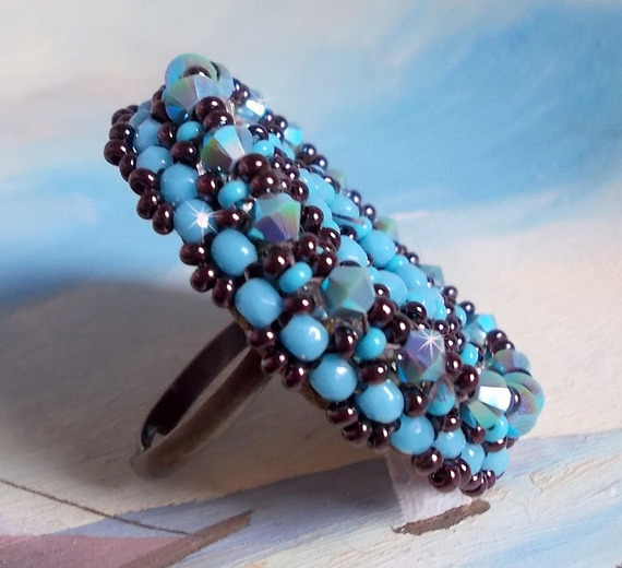 Anel naïade bordado com uma resina azul turquesa e cabochon de cristal, um belo jogo de luz.
