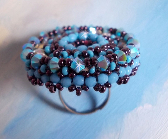 Anel naïade bordado com uma resina azul turquesa e cabochon de cristal, um belo jogo de luz.