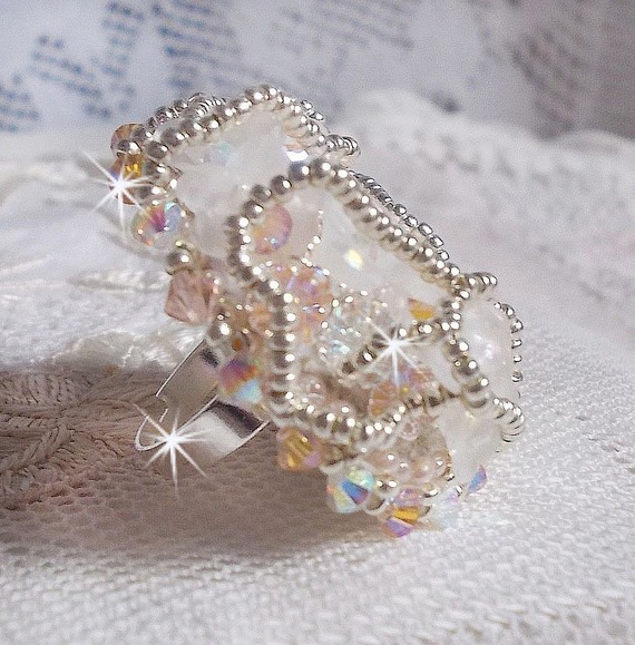 Anel Bouquet d'un Jour bordado com lírios de lucite, topos giratórios de cristal Swarovski, um cabochon perolado com missangas de prata e salmão