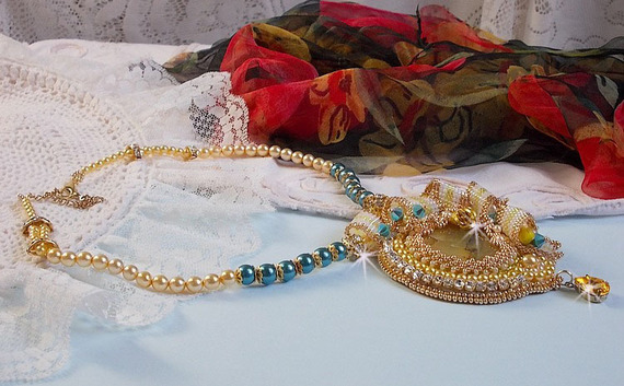 Pingente Haute-Couture Sunflower Gold bordado com contas de sementes douradas de 24 quilates, uma opala malgaxe e cristais Swarovski.