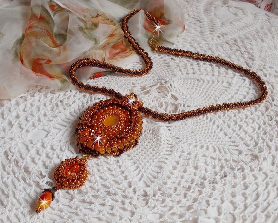 O colar pendente Lady in Orange é bordado com cristais Swarovski, missangas de sementes Miyuki e missangas mágicas.