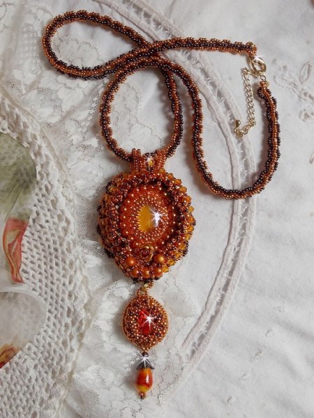O colar pendente Lady in Orange é bordado com cristais Swarovski, missangas de sementes Miyuki e missangas mágicas.