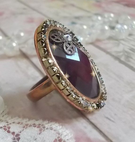 Anel Chic Burgundy criado com cristais PureCrystal, um selo em forma de flor e um cabochon de vidro.