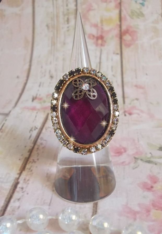 Anel Chic Burgundy criado com cristais PureCrystal, um selo em forma de flor e um cabochon de vidro.
