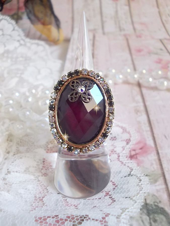 Anel Chic Burgundy criado com cristais PureCrystal, um selo em forma de flor e um cabochon de vidro.