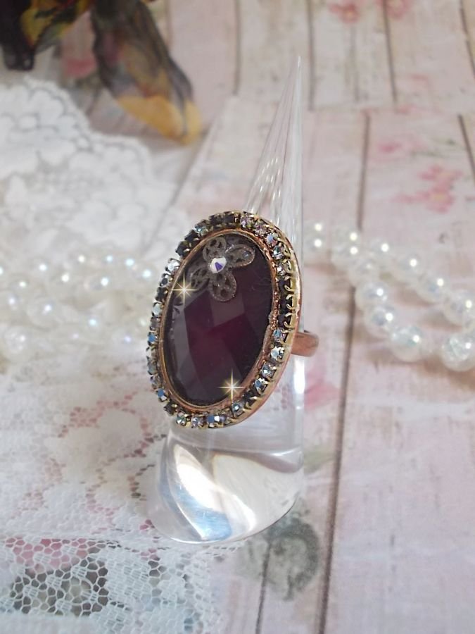 Anel Chic Burgundy criado com cristais PureCrystal, um selo em forma de flor e um cabochon de vidro.