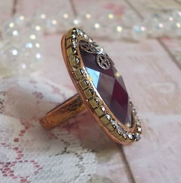 Anel Chic Burgundy criado com cristais PureCrystal, um selo em forma de flor e um cabochon de vidro.