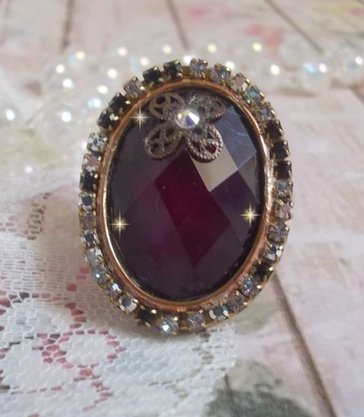 Anel Chic Burgundy criado com cristais PureCrystal, um selo em forma de flor e um cabochon de vidro.