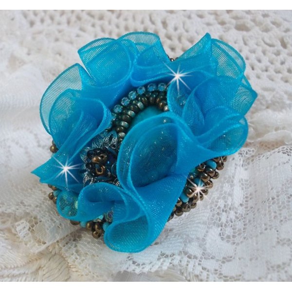 Ilycia Charming ring bordado com um cabochon facetado de resina azul turquesa e uma fita de organza