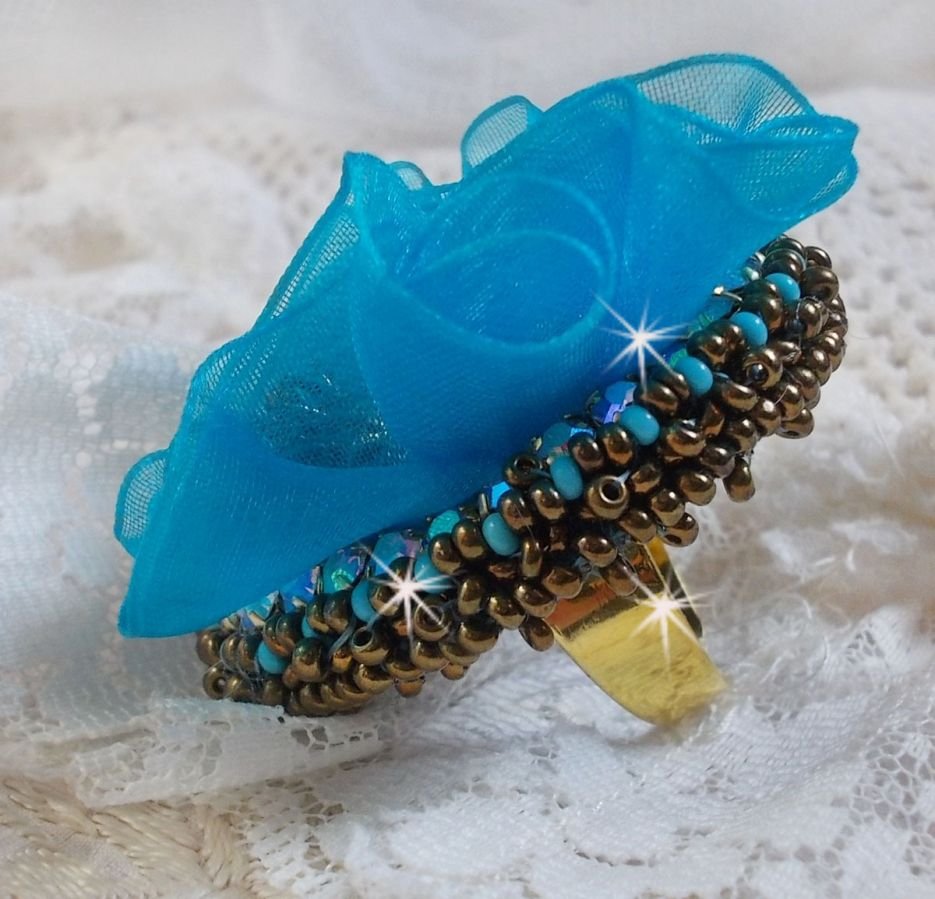 Ilycia Charming ring bordado com um cabochon facetado de resina azul turquesa e uma fita de organza