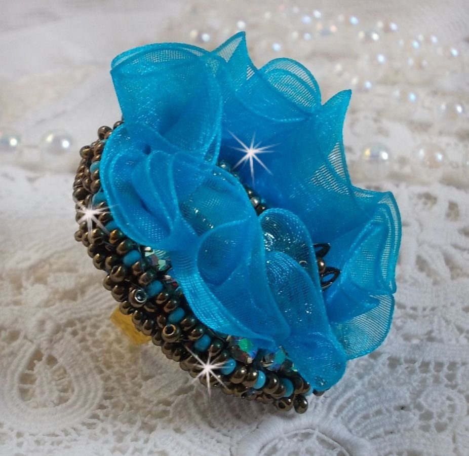 Ilycia Charming ring bordado com um cabochon facetado de resina azul turquesa e uma fita de organza