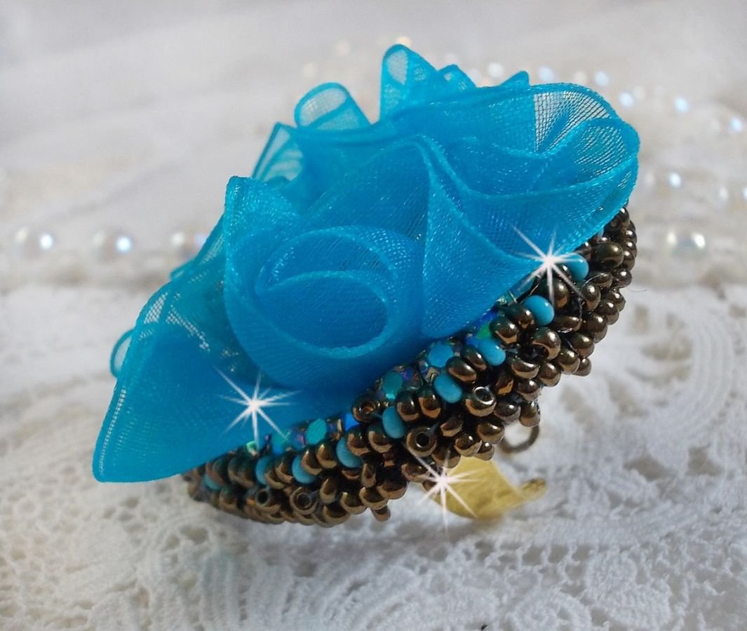 Ilycia Charming ring bordado com um cabochon facetado de resina azul turquesa e uma fita de organza