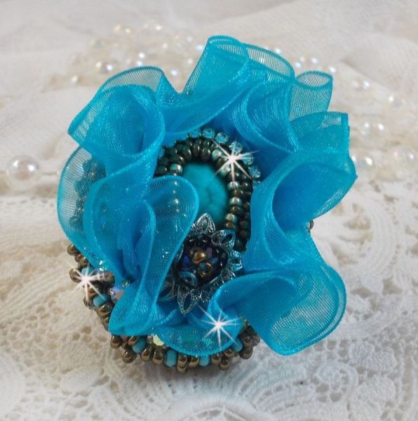 Ilycia Charming ring bordado com um cabochon facetado de resina azul turquesa e uma fita de organza
