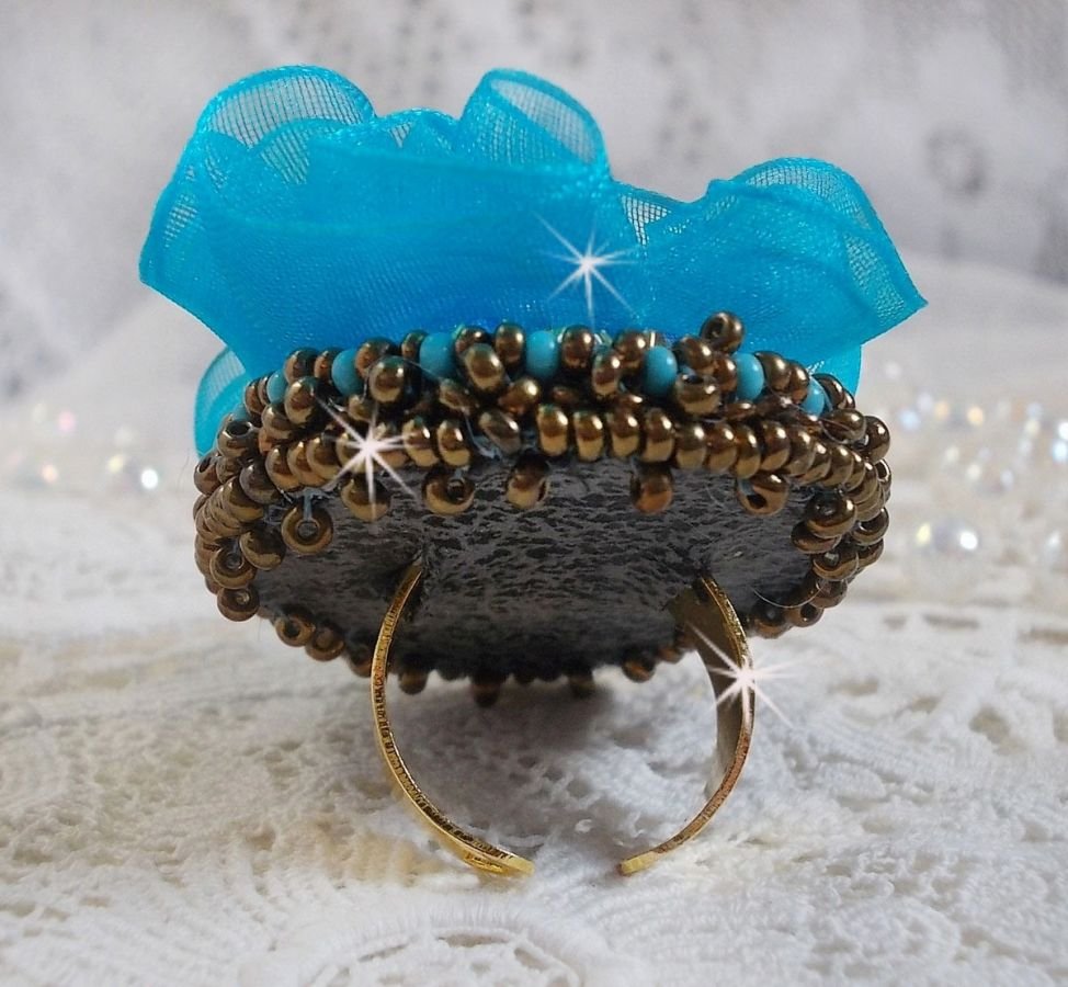 Ilycia Charming ring bordado com um cabochon facetado de resina azul turquesa e uma fita de organza