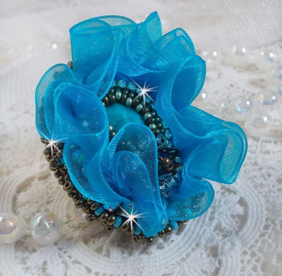 Ilycia Charming ring bordado com um cabochon facetado de resina azul turquesa e uma fita de organza