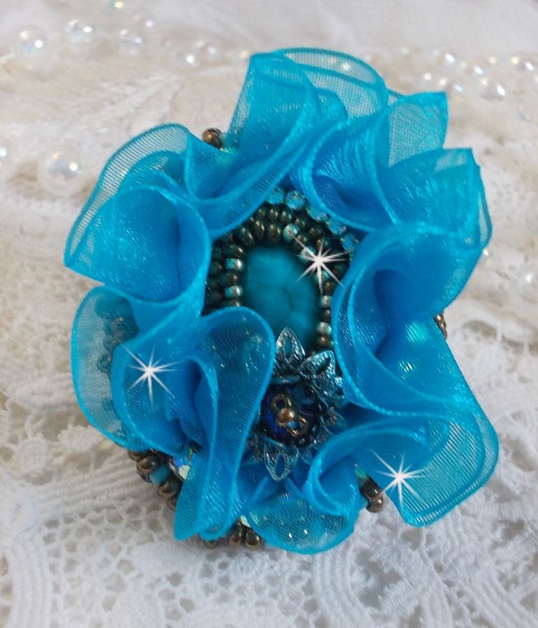 Ilycia Charming ring bordado com um cabochon facetado de resina azul turquesa e uma fita de organza