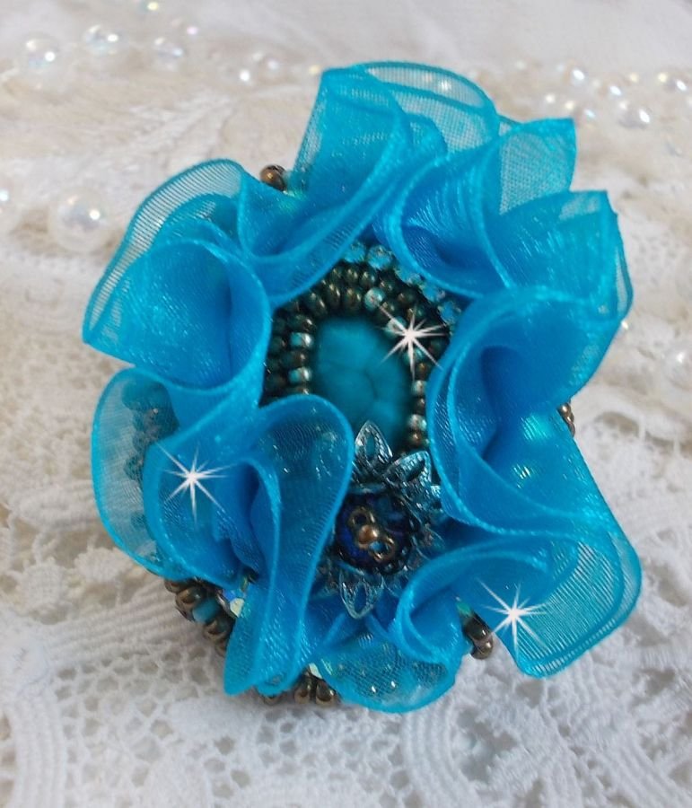 Ilycia Charming ring bordado com um cabochon facetado de resina azul turquesa e uma fita de organza