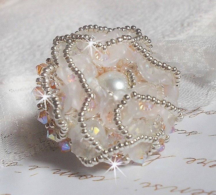 Anel Bouquet d'un Jour bordado com lírios de lucite, topos giratórios de cristal Swarovski, um cabochon perolado com missangas de prata e salmão