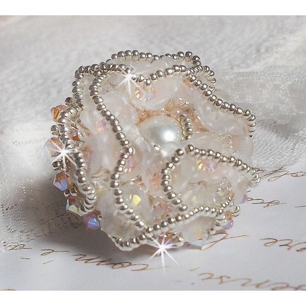 Anel Bouquet d'un Jour bordado com lírios de lucite, topos giratórios de cristal Swarovski, um cabochon perolado com missangas de prata e salmão