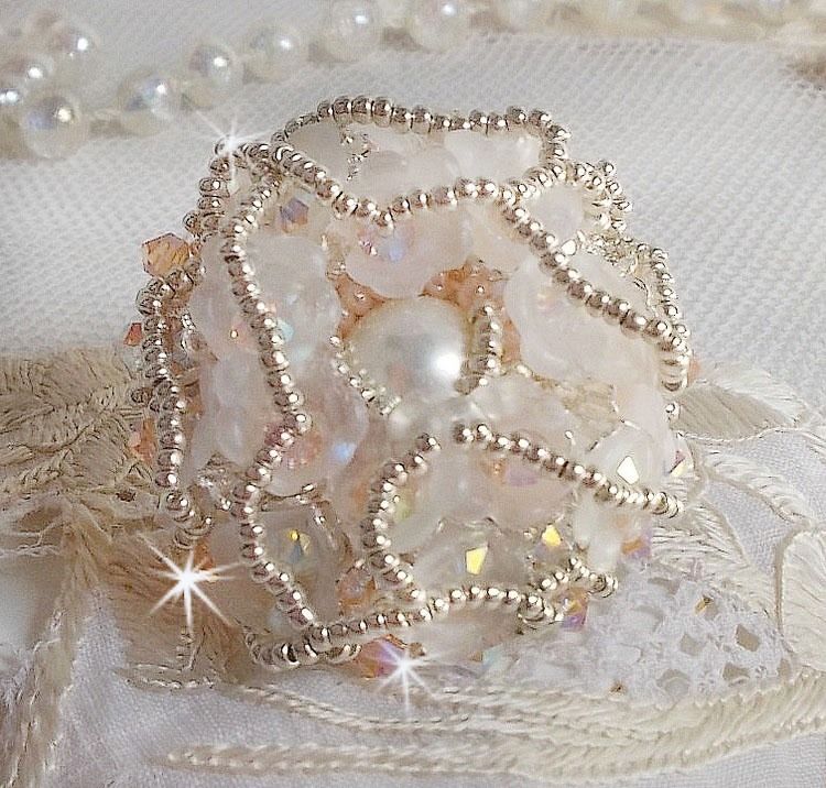 Anel Bouquet d'un Jour bordado com lírios de lucite, topos giratórios de cristal Swarovski, um cabochon perolado com missangas de prata e salmão