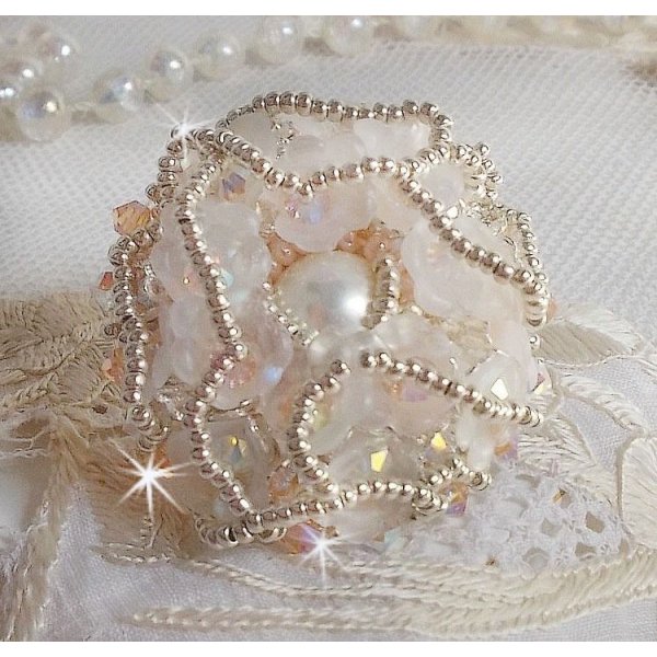 Anel Bouquet d'un Jour bordado com lírios de lucite, topos giratórios de cristal Swarovski, um cabochon perolado com missangas de prata e salmão