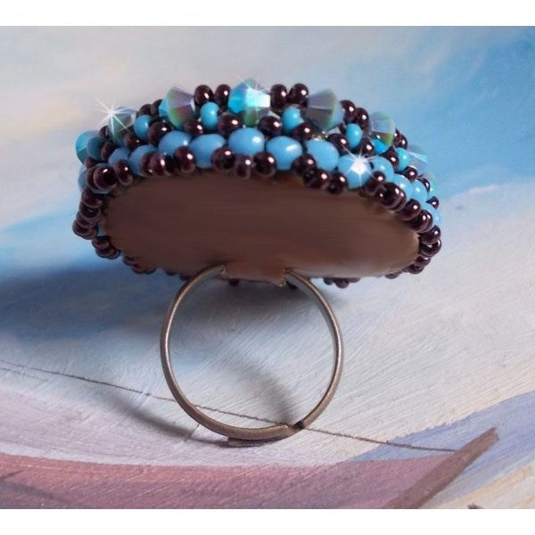 Anel naïade bordado com uma resina azul turquesa e cabochon de cristal, um belo jogo de luz.