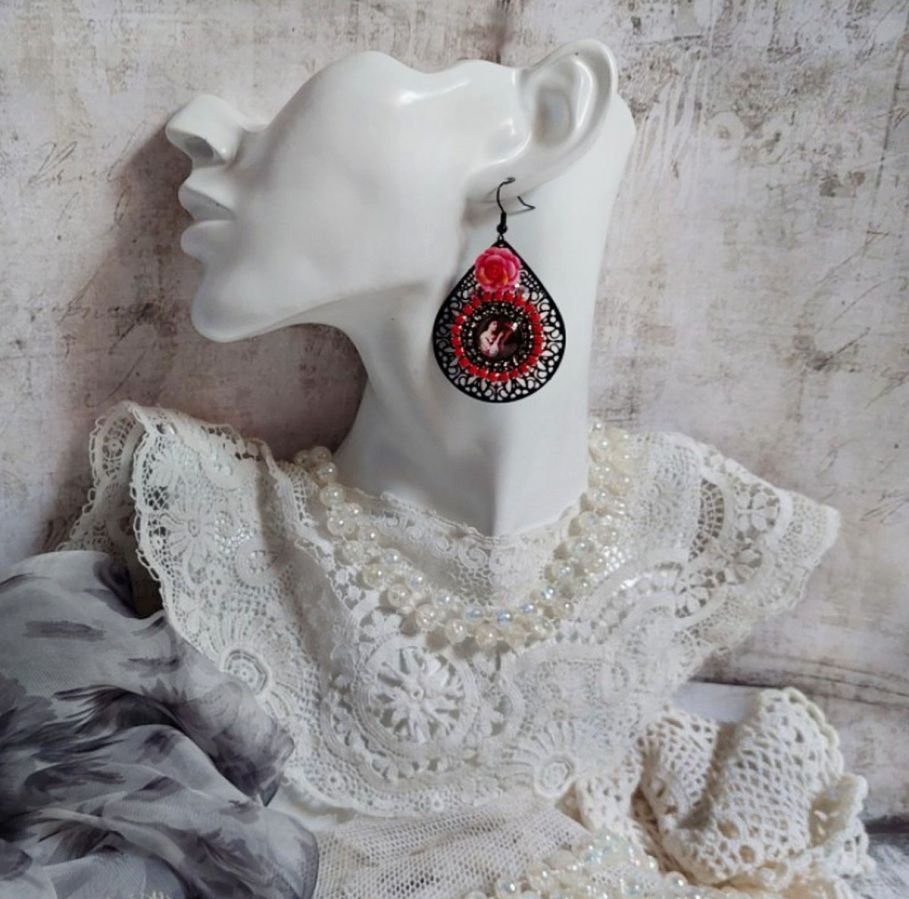 BO Look Coco criado com cabochons de lupa representando uma mulher com o seu papagaio, pingentes pretos de filigrana, contas de vidro e resina