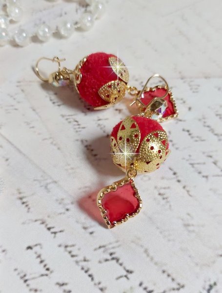 BO Passionn&eacute;ment mont&eacute;es avec des pompons Rouges tr&egrave;s tendances &agrave; laquelle s&rsquo;ajoute des coupelles en forme d&rsquo;arabesque, pendentifs vitrail Rouge/Dor&eacute; et cabochons en Cristal AB sur crochets en Laiton