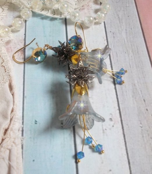 BO Sensations Ouro e Azul criado com flores de trompete pintadas &agrave; m&atilde;o, cristais, flores de vidro e acess&oacute;rios banhados a ouro