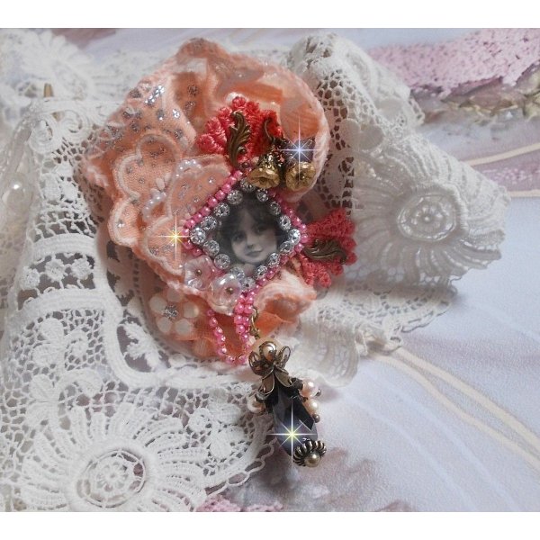 Pregadeira r&uacute;stica Rose criada com um cabochon representando uma rapariga sorridente, rhinestone laranja e renda Rose, cristais, contas de vidro e v&aacute;rios acess&oacute;rios