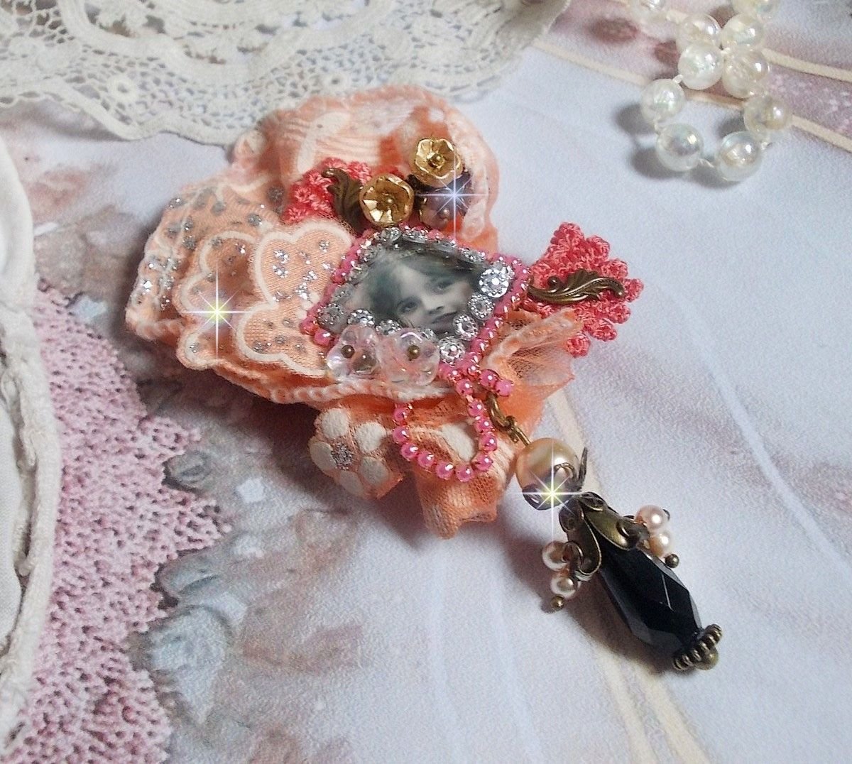 Pregadeira rústica Rose criada com um cabochon representando uma rapariga sorridente, rhinestone laranja e renda Rose, cristais, contas de vidro e vários acessórios