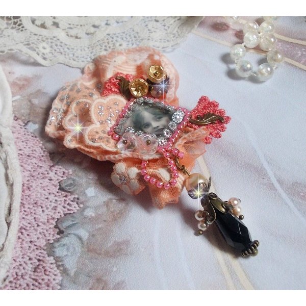Pregadeira r&uacute;stica Rose criada com um cabochon representando uma rapariga sorridente, rhinestone laranja e renda Rose, cristais, contas de vidro e v&aacute;rios acess&oacute;rios