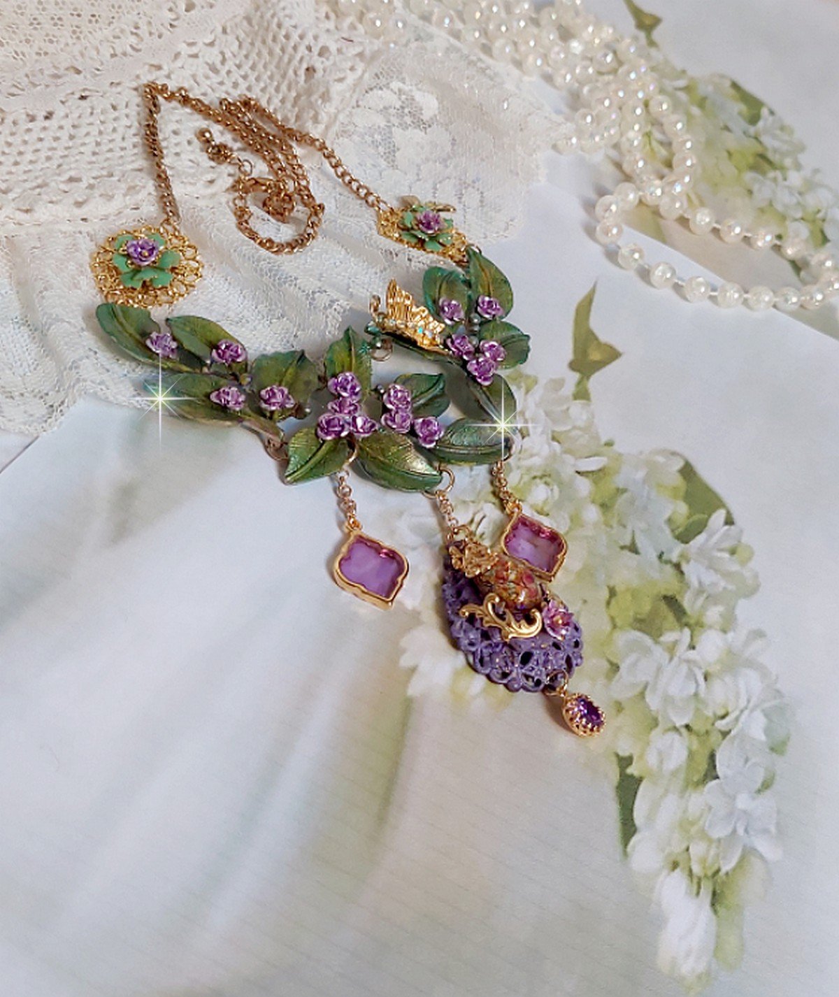 Collier Cam&eacute;lia Japonica mont&eacute; avec un motif feuilles aquarell&eacute;s &agrave; la main, paillettes, breloques papillons et abeille, roses m&eacute;tal, cabochon cristal, pendentifs &eacute;poxy aux couleurs d&rsquo;arc en ciel