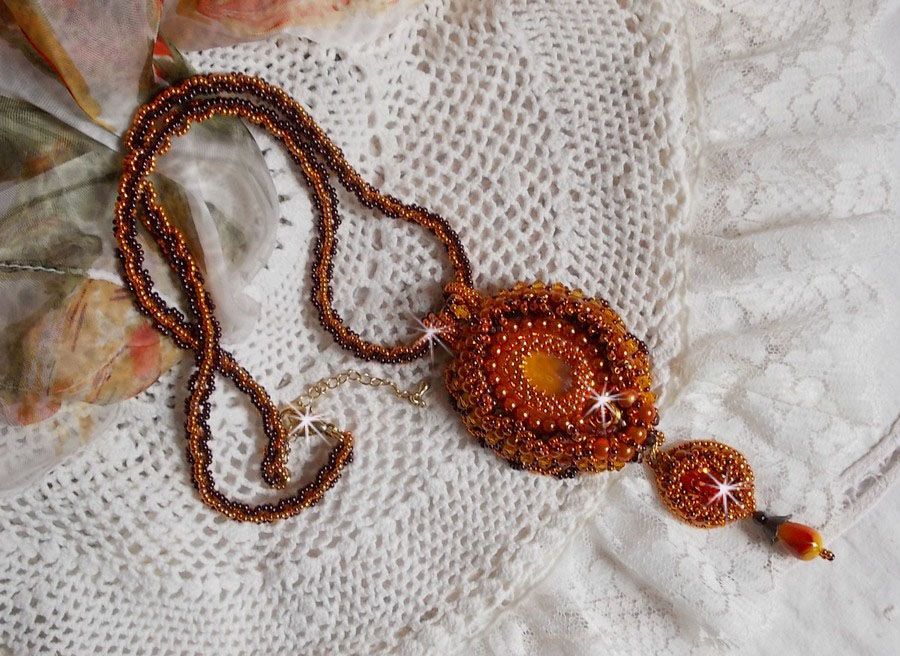 O colar pendente Lady in Orange é bordado com cristais Swarovski, missangas de sementes Miyuki e missangas mágicas.