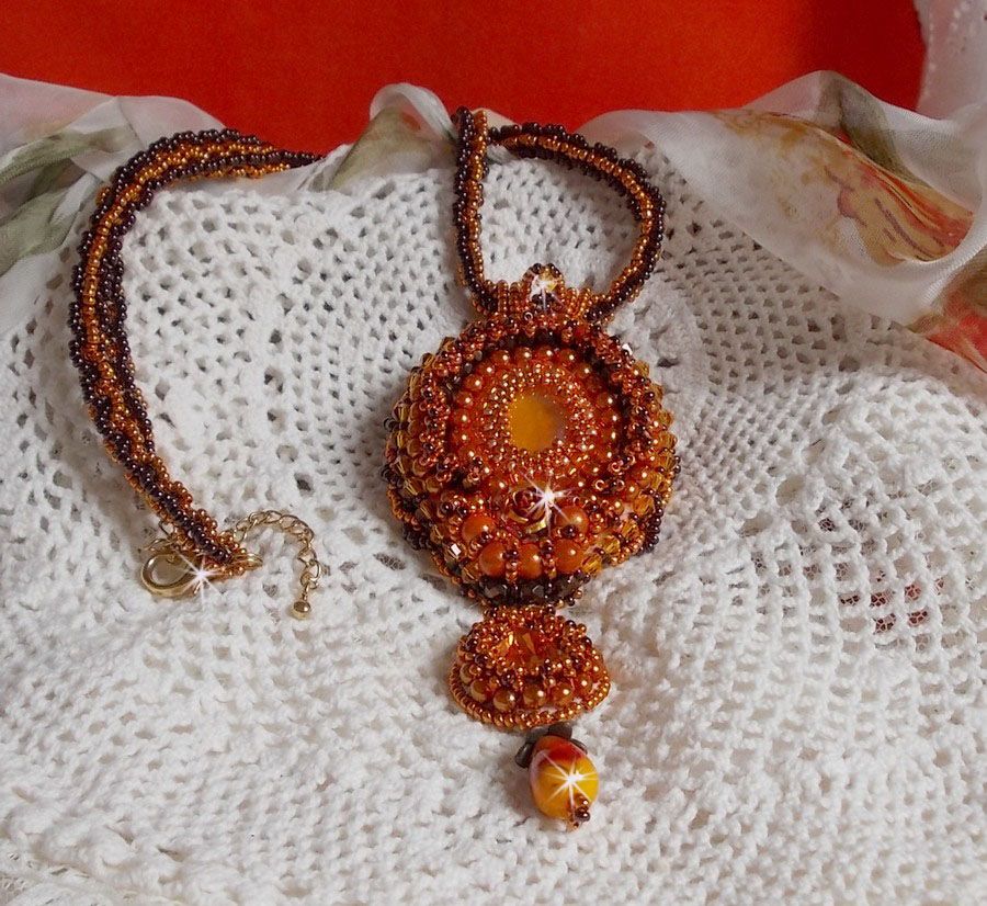 O colar pendente Lady in Orange é bordado com cristais Swarovski, missangas de sementes Miyuki e missangas mágicas.