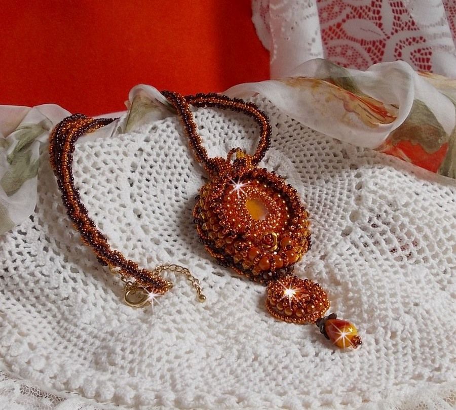 O colar pendente Lady in Orange é bordado com cristais Swarovski, missangas de sementes Miyuki e missangas mágicas.
