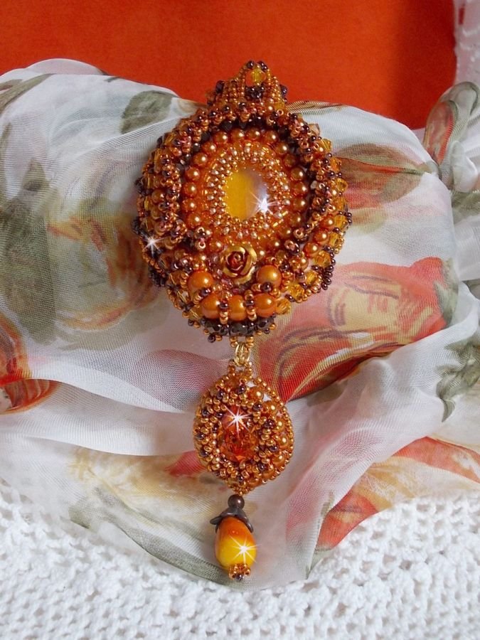 O colar pendente Lady in Orange é bordado com cristais Swarovski, missangas de sementes Miyuki e missangas mágicas.