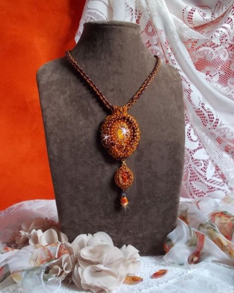 O colar pendente Lady in Orange &eacute; bordado com cristais Swarovski, missangas de sementes Miyuki e missangas m&aacute;gicas.