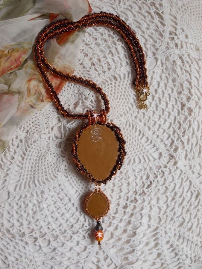 O colar pendente Lady in Orange é bordado com cristais Swarovski, missangas de sementes Miyuki e missangas mágicas.