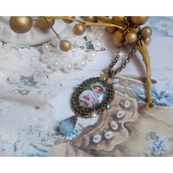 Pendentif Douce Dame cr&eacute;&eacute; avec un cabochon repr&eacute;sentant une femme au chapeau blanc orn&eacute; de cristaux, des accessoires de couleur Bronze et un jade teint&eacute; bleu 